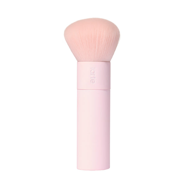 A tarte cosmetics pink makeup brush with soft, rounded bristles and a pink handle, on a white background.