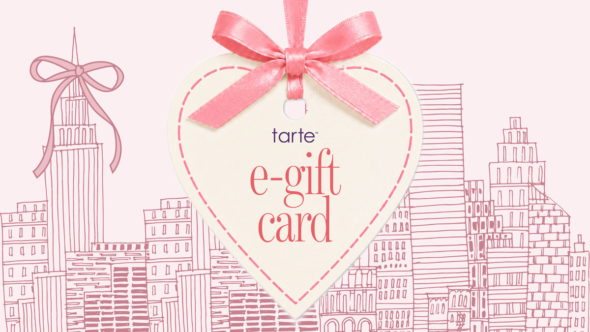 A heart-shaped e-gift card from tarte, featuring a pink satin ribbon bow at the top, set against a light pink background with a pink line-art cityscape illustration.
