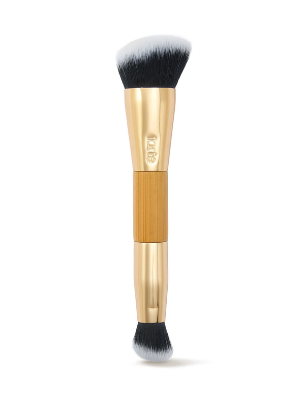 Makeup brush with gold handle and black bristles on a white background