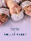 Three women lying down wearing matching white sleep masks, with the text 'tarte x ROLLER RABBIT' at the bottom on a lavender background.