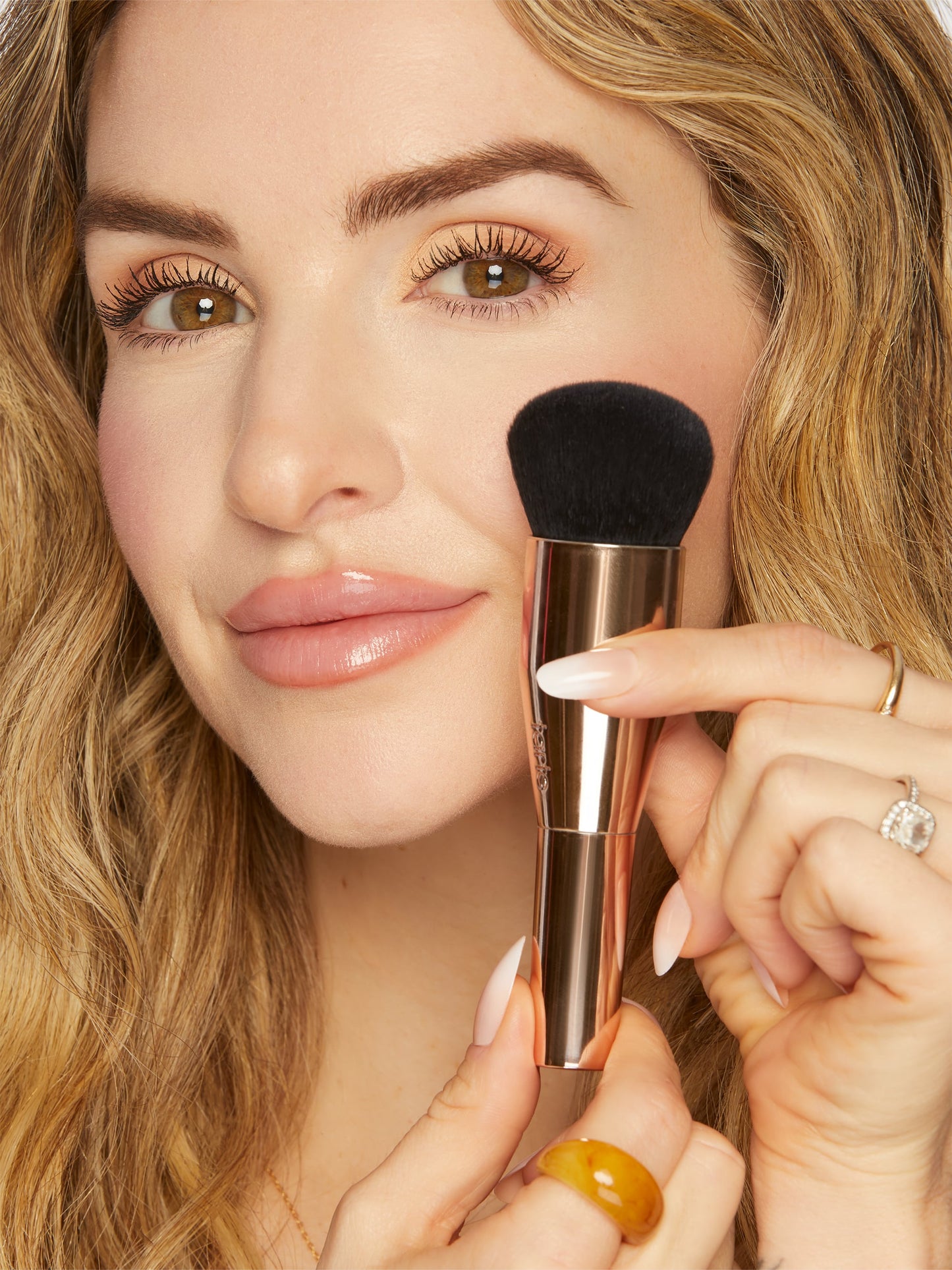 Woman holding a makeup brush near her face