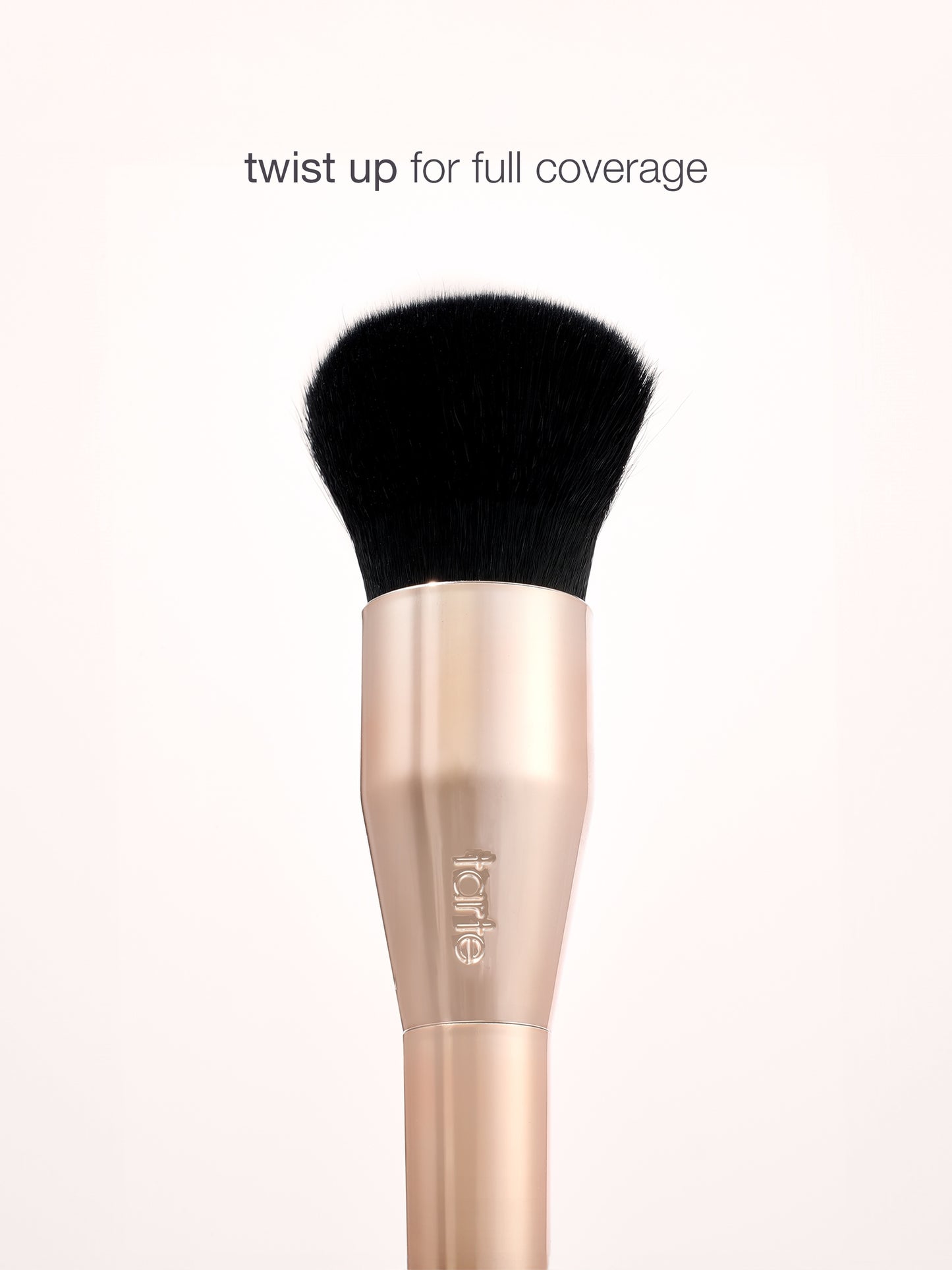 Makeup brush with black bristle head and rose gold handle on a white background