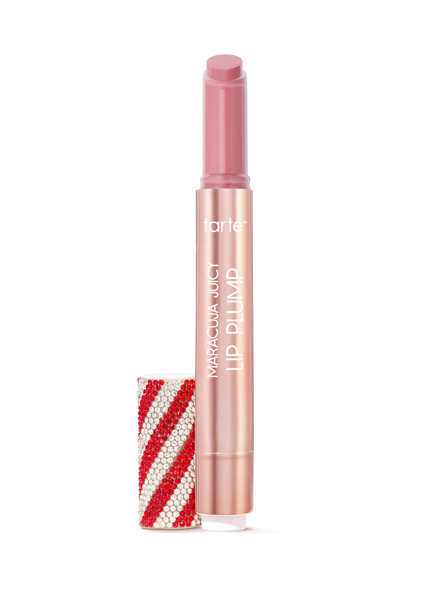 A pink lipstick extends from a gold tube labeled Tarte Maracuja Juicy Lip Plump, beside a bejeweled red and white striped cap, set against a plain white background.