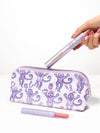 woman holding a tarte cosmetics x roller rabbit collaboration makeup bag, maracuja juicy lip vinyl, and tartelette tubing mascara against a white background