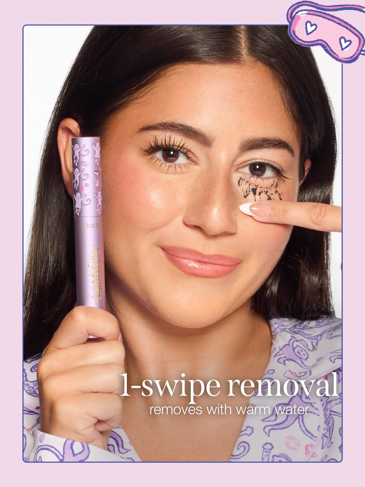 A woman removing tarte cosmetics x roller rabbit collaboration tartelette tubing mascara with limited edition cap with text reading '1-swipe removal' and 'removes with warm water.'