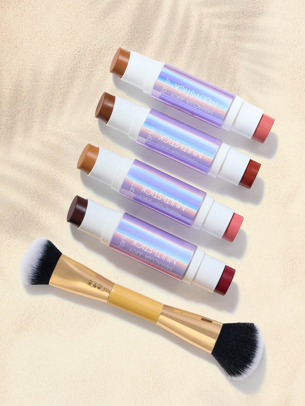 Set of makeup brushes with colorful handles on a beige background