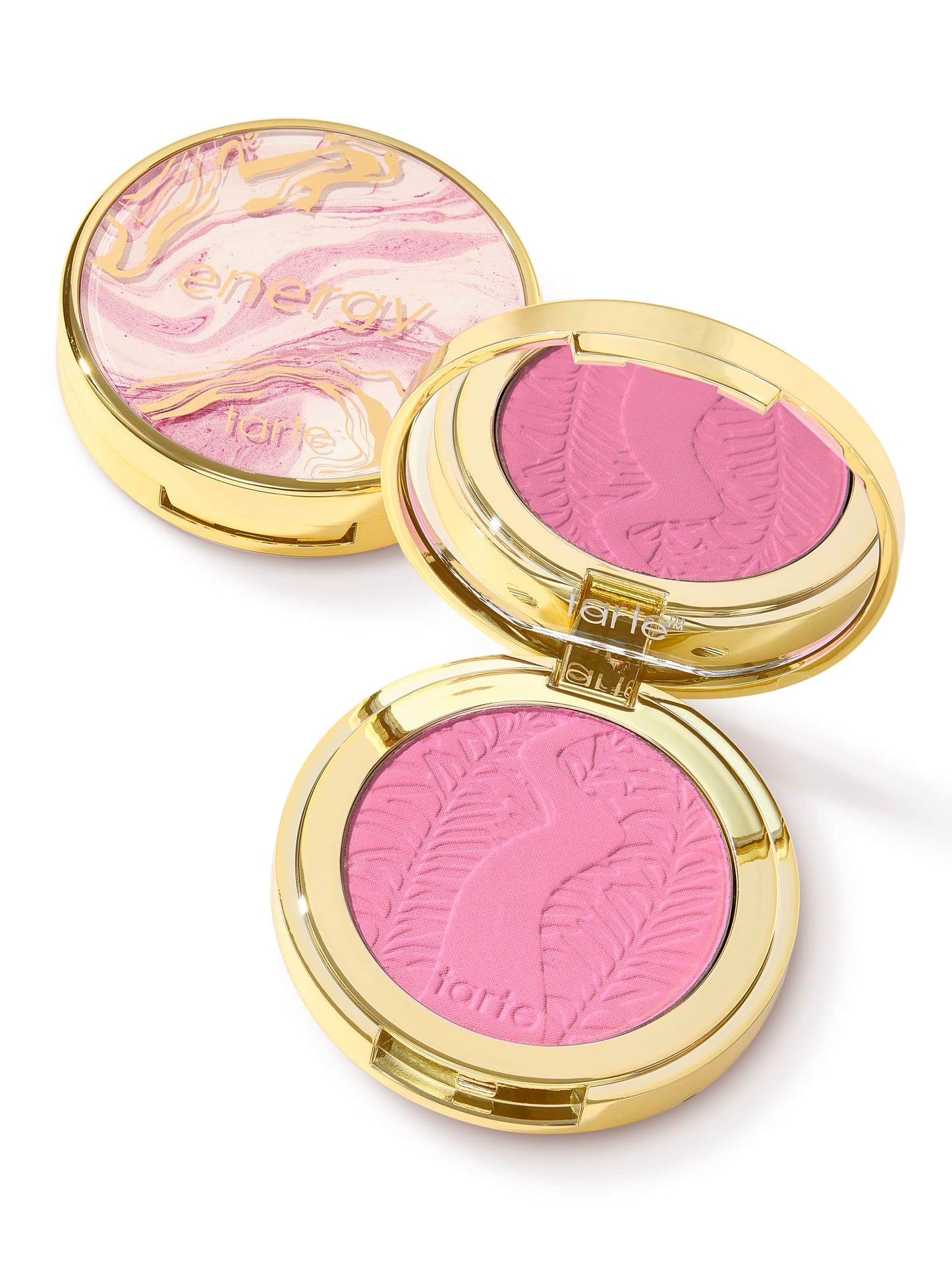 Compact blush with a pink, embossed design sits open alongside its closed counterpart. The closed compact features a marbled lid with gold accents and text energy and tarte.