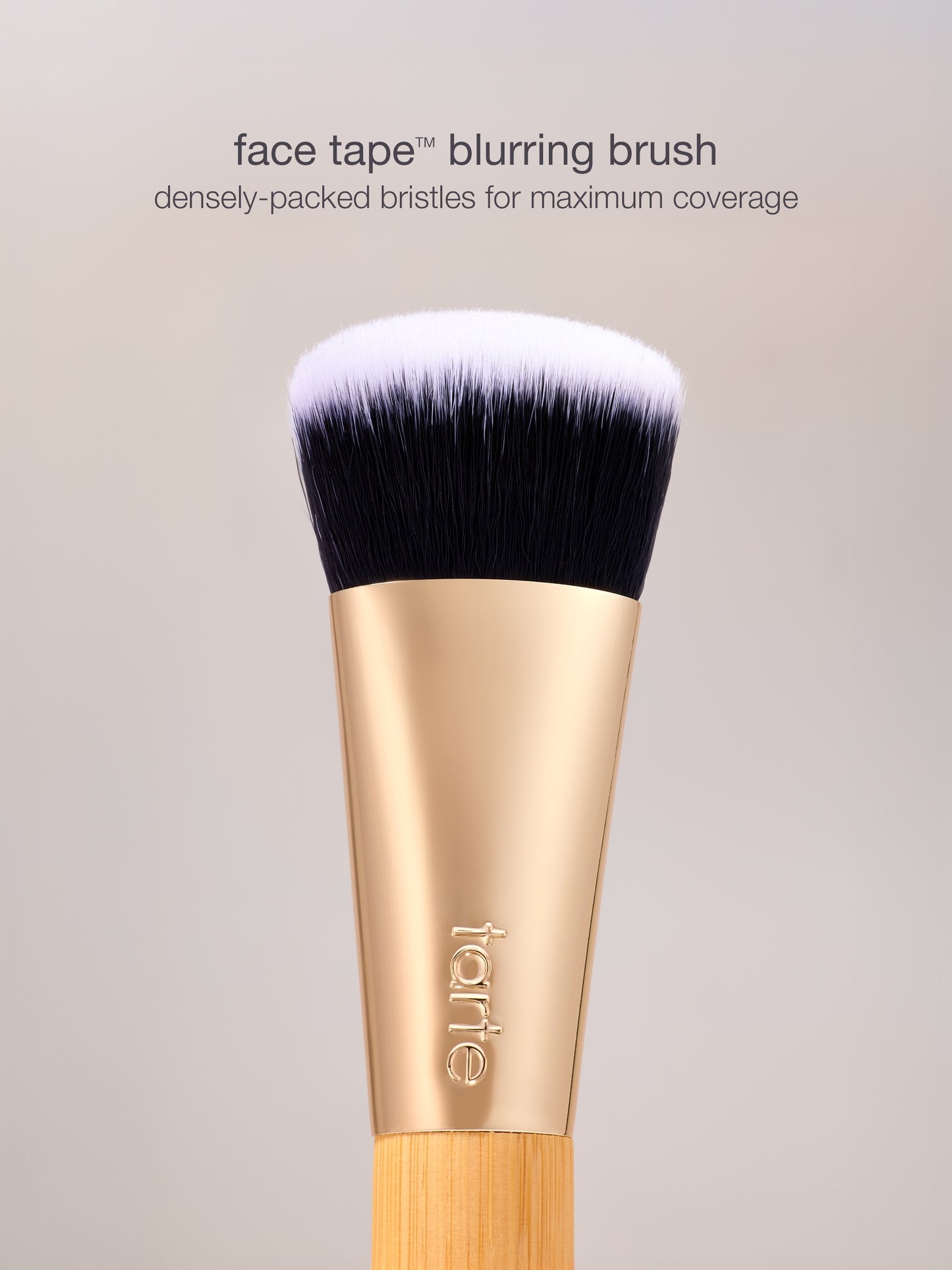 Makeup brush with black bristles and gold handle on a gray background, featuring the brand 'itarte'.