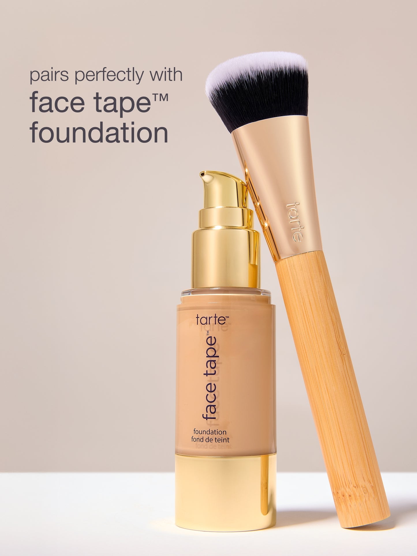 Tarte face tape foundation bottle with brush on a beige background