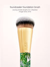 Foundation brush with gold ferrule and leaf-patterned handle on a white background