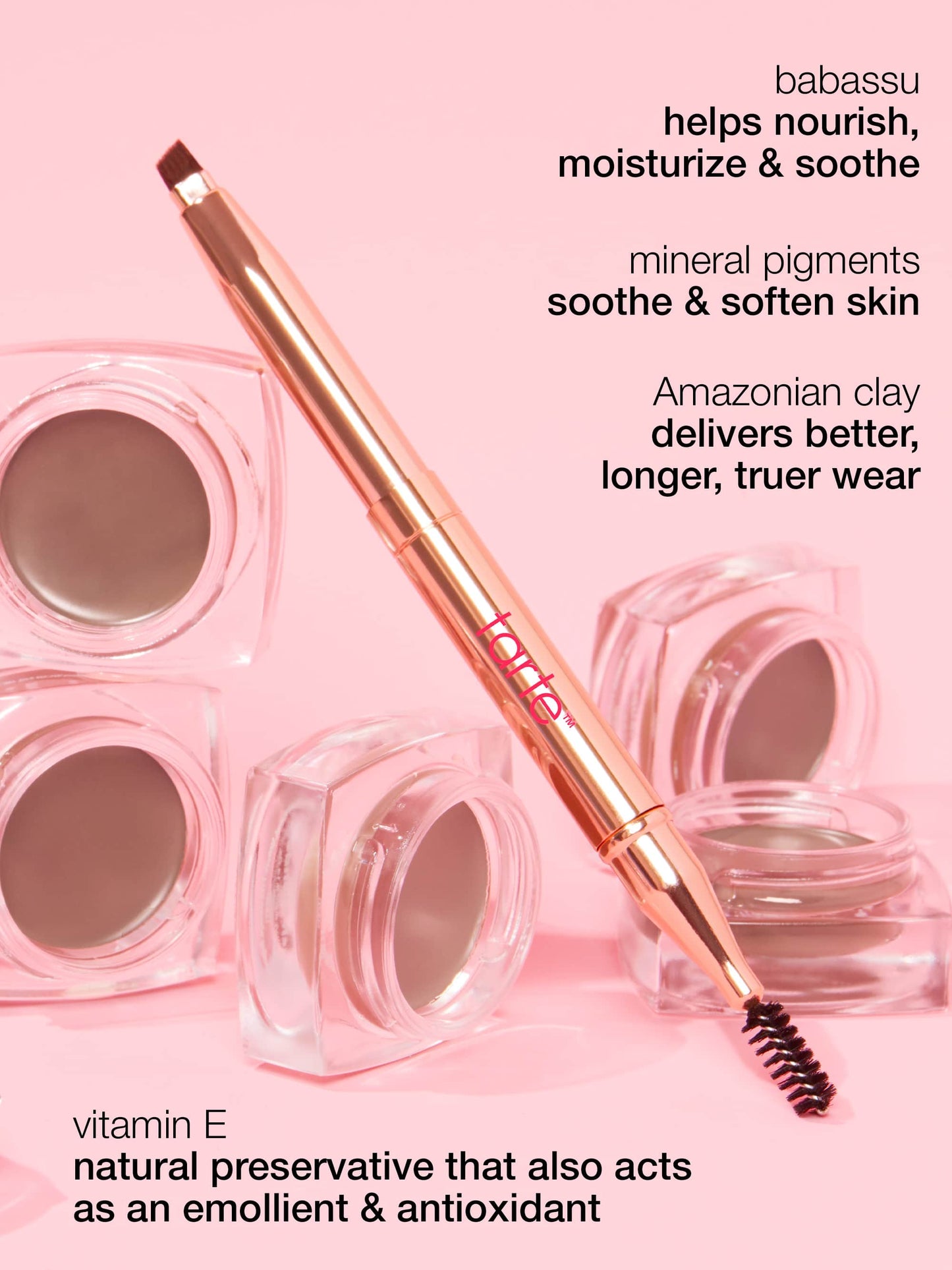 A dual-ended makeup tool is displayed among small jars on a pink surface. Text highlights its ingredients: babassu, mineral pigments, Amazonian clay, and vitamin E, describing their nourishing and soothing benefits.