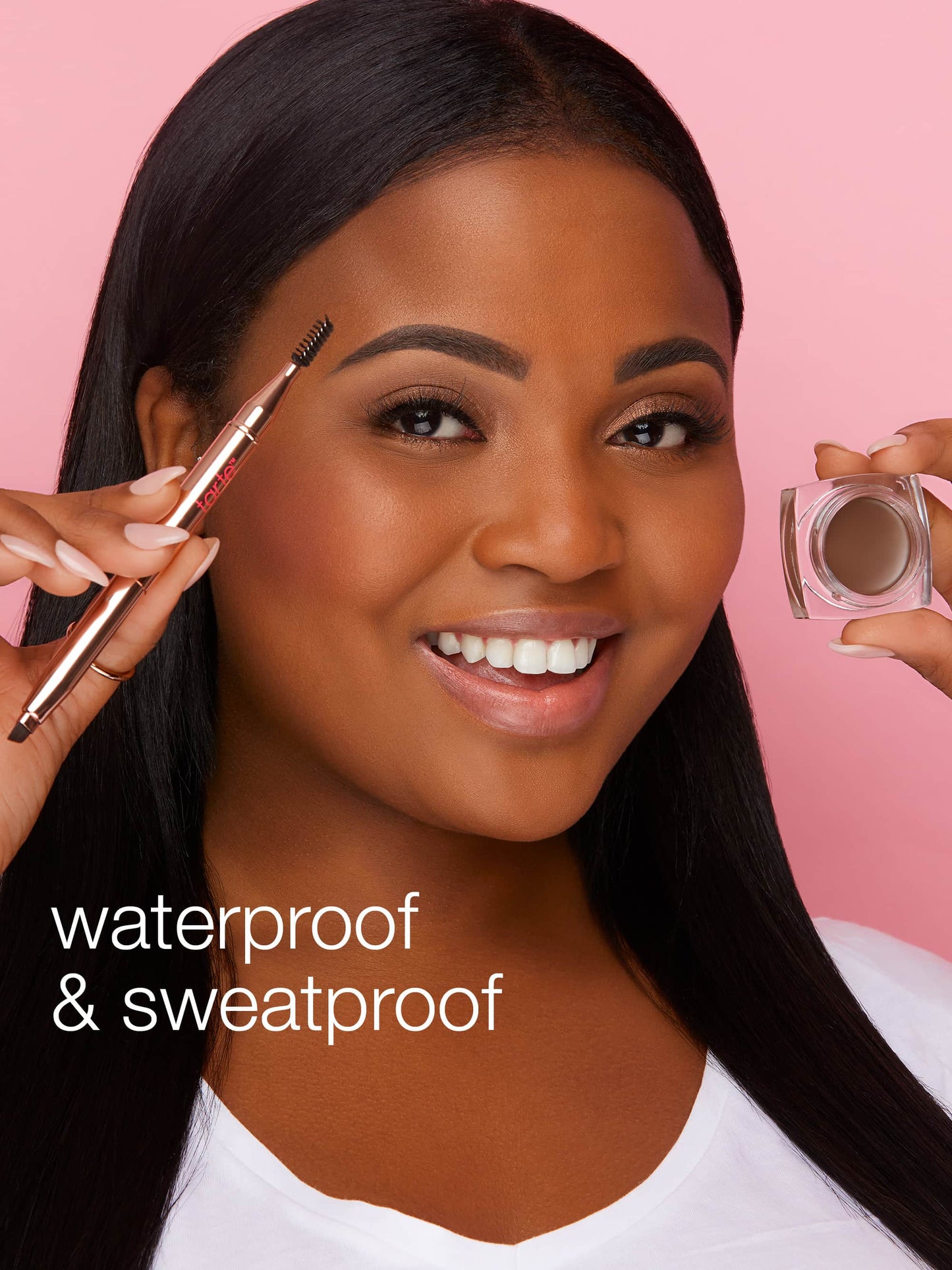 A person holds a brow brush and a jar of eyebrow product, smiling against a pink background. Text reads waterproof & sweatproof.