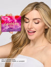 Woman holding a Tartelette in Bloom makeup palette with a white background
