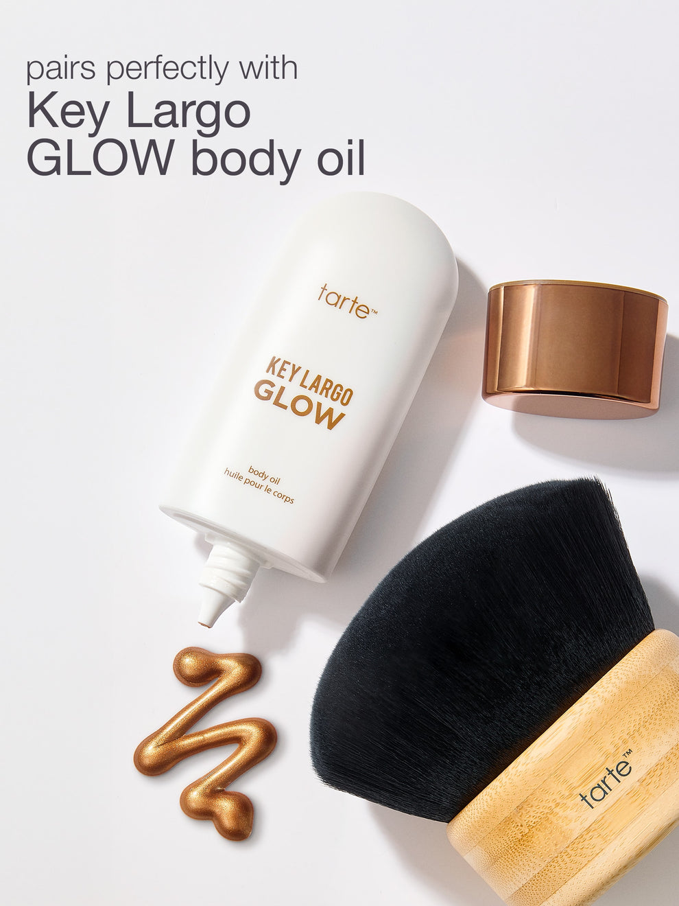 Tarte Key Largo Glow body oil with a brush on a white background