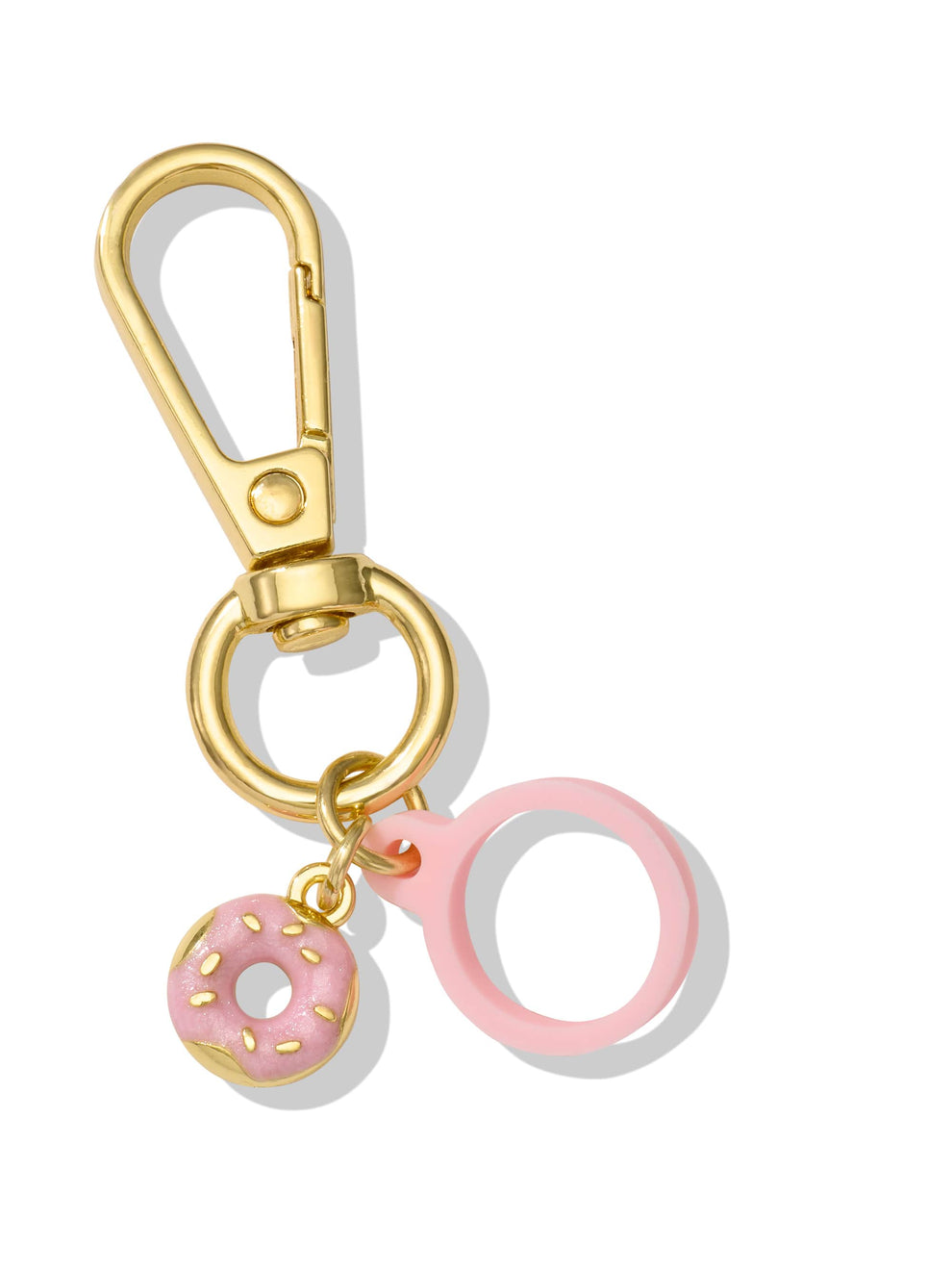 A gold keychain features a decorative pink donut charm with sprinkles and a pink loop, set against a plain white background.