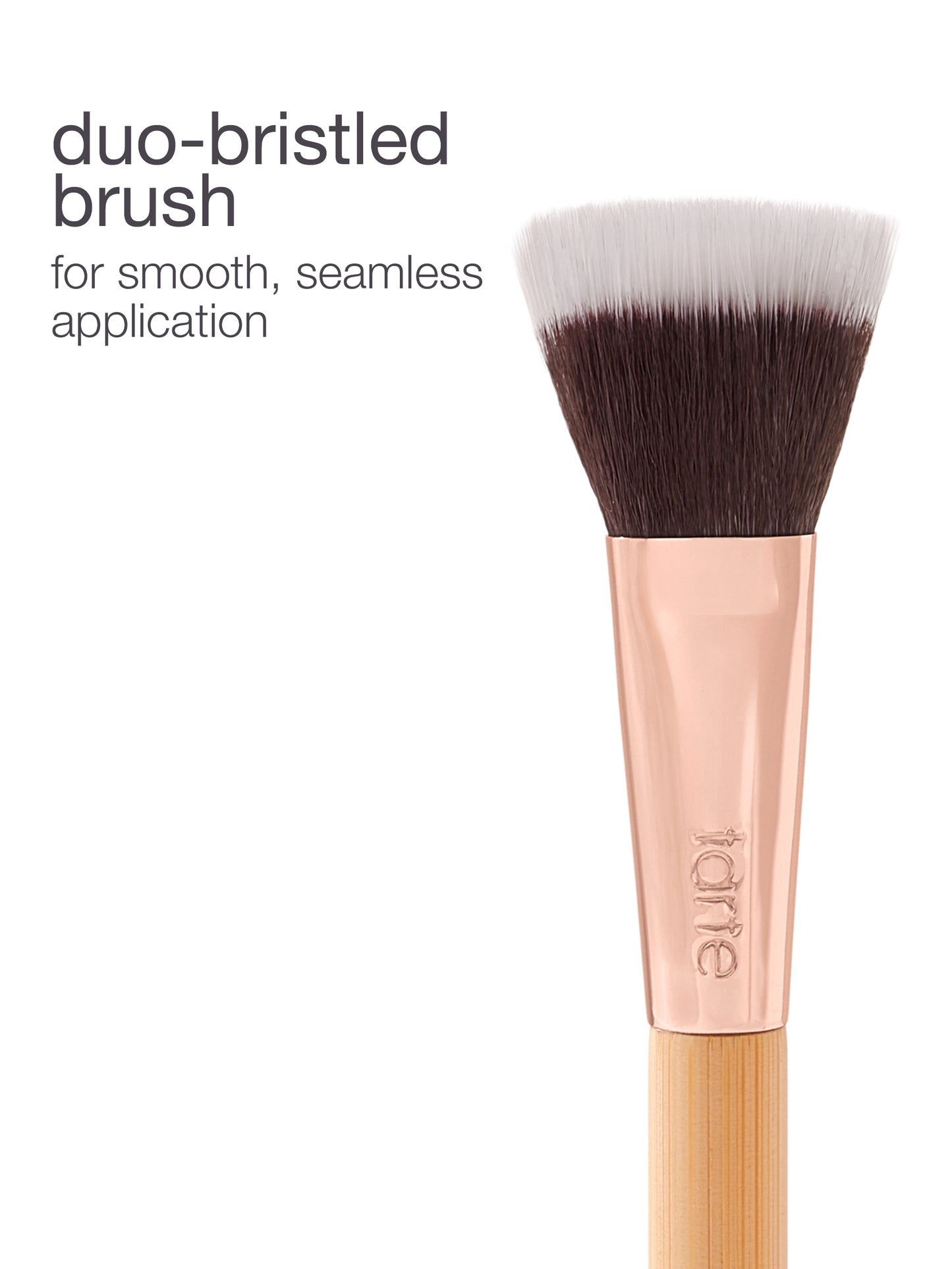 Duo-bristled makeup brush with soft, dense bristles on a wooden handle, embossed with tarte, designed for smooth application. Text: duo-bristled brush for smooth, seamless application. White background.