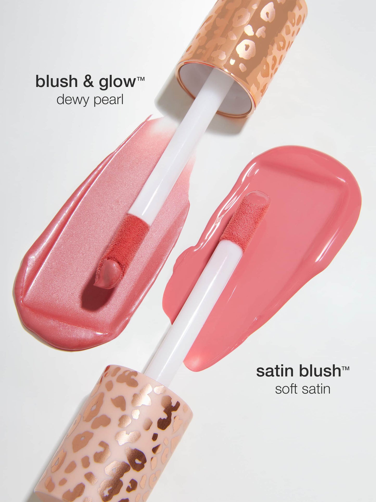Two makeup applicators spread blushes on a white surface. Blush & glow in dewy pearl is on the left, and satin blush in soft satin on the right. Caps have a leopard print.
