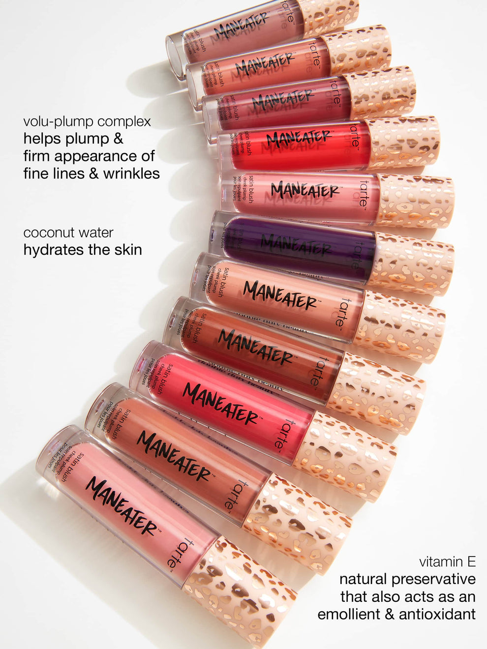 Tubes labeled MANEATER by Tarte Cosmetics lie horizontally, showcasing various shades of satin blush. Text highlights volu-plump complex for firming lines, coconut water for hydration, and vitamin E as an antioxidant.