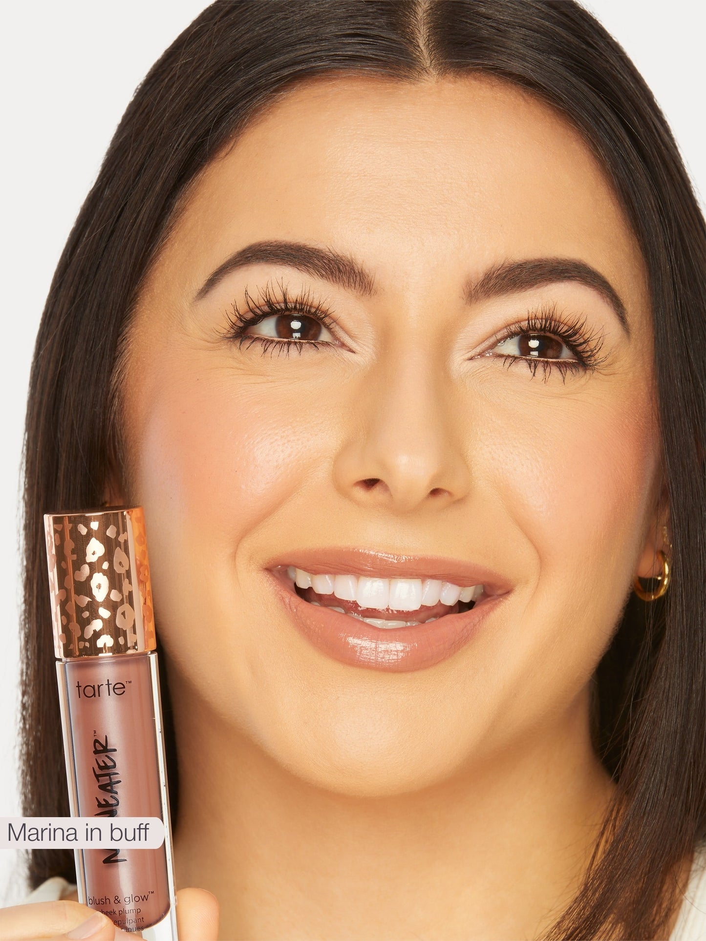 Woman holding a tarte makeup product with a close-up of the product.