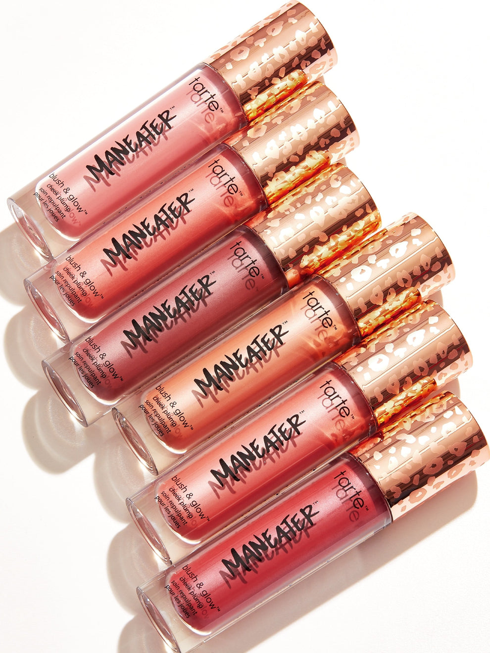 Set of Maneater lip glosses in various shades on a white background