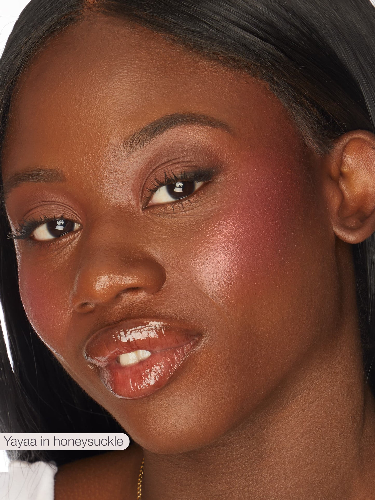 Close-up of a woman's face with makeup, wearing a gold earring.