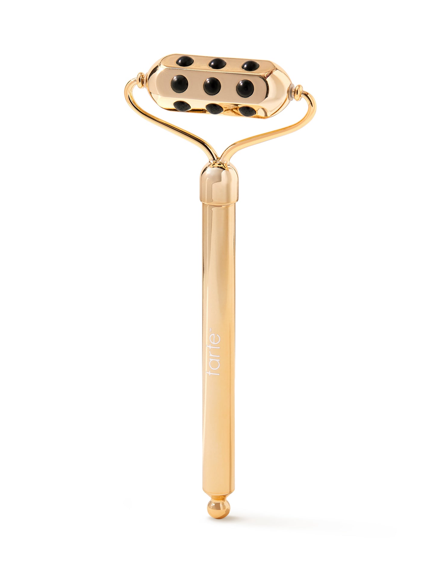 Gold facial roller with black stones on a white background