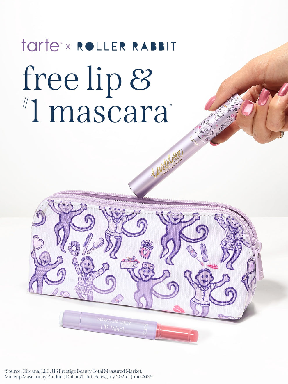 A hand holds a limited edition tarte cosmetics x roller rabbit collaboration tartelette tubing mascara above a white zip pouch printed with purple cartoon monkeys. A matching lip item lies in front of the pouch.