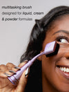 woman using the tarte shape tape blur stick brush with text 'multitasking brush designed for liquid, cream, & powder formulas'
