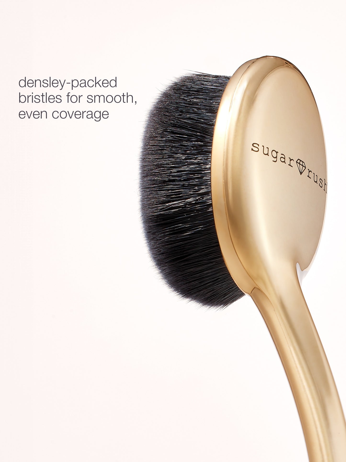 Makeup brush with gold handle and black bristles on a white background, featuring the brand 'sugar rush'.