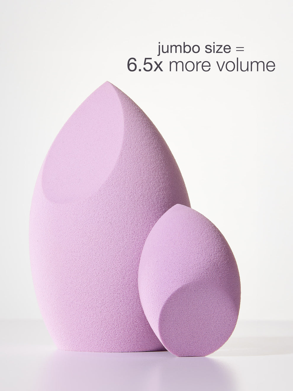 Two pink makeup sponges with text indicating jumbo size and volume on a light gray background