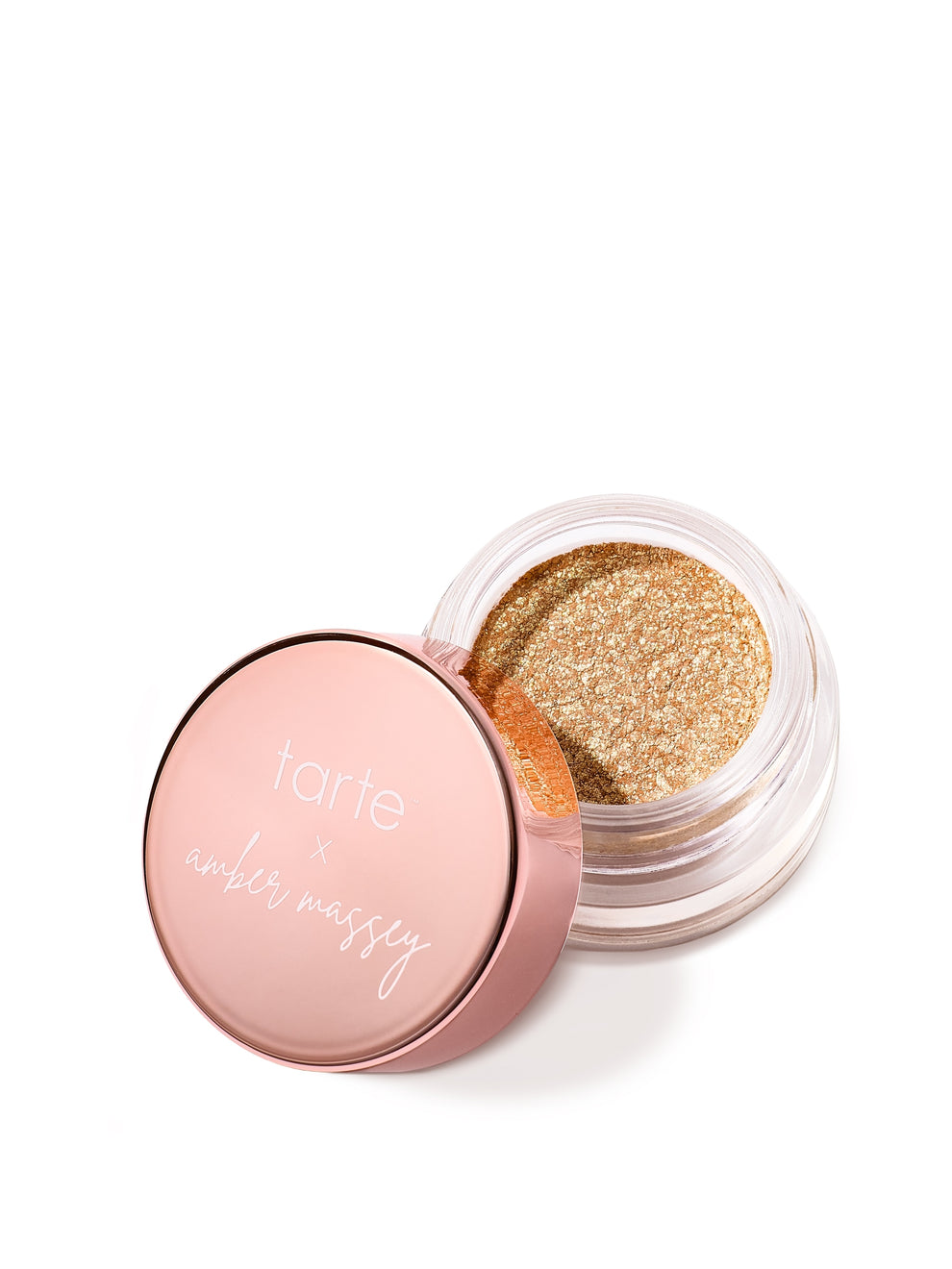 A small jar of shimmering gold eyeshadow with an open rose-gold lid. The lid features the text tarte x amber massey. The jar rests on a white background.