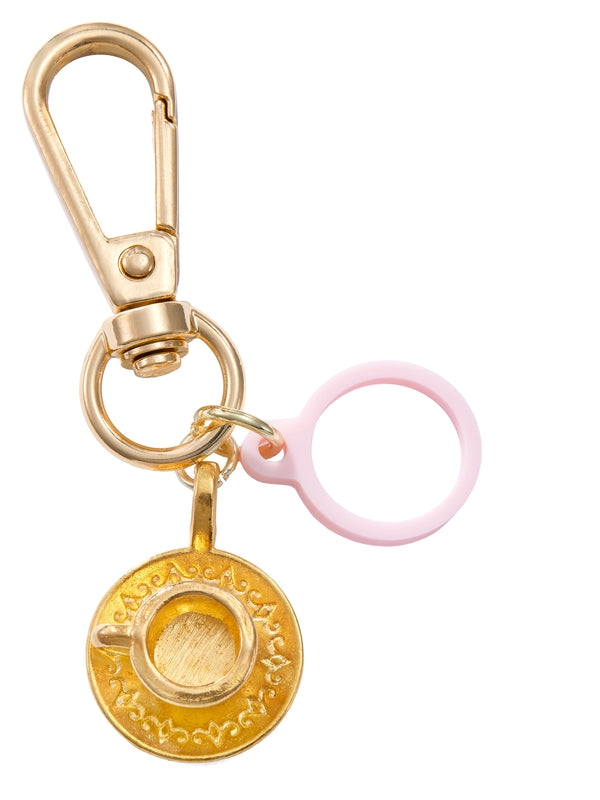 Gold keychain with a pink ring and decorative charm on a white background