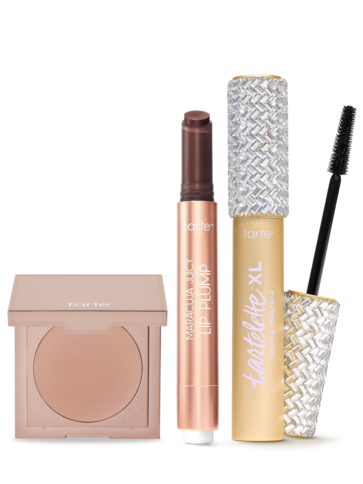 Compact blush, lip plump stick, and XL tubing mascara are arranged upright on a white background. Each item is labeled with tarte branding, featuring shiny and textured packaging designs.