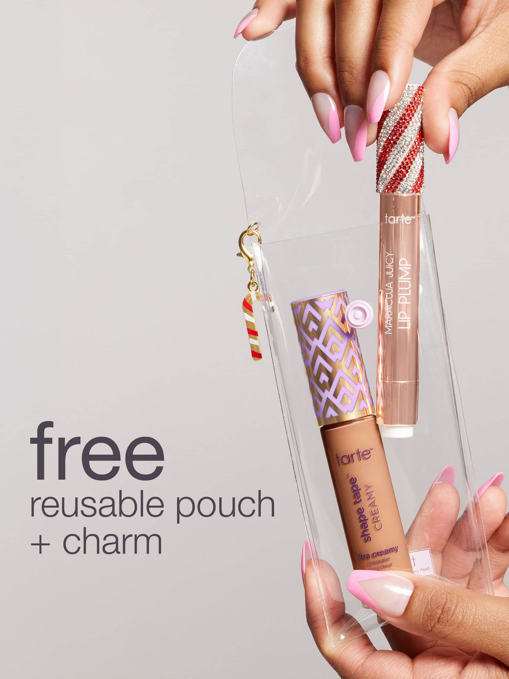 Two hands hold a transparent pouch containing Tarte Cosmetics products: a shape tape creamy concealer and Maracuja Juicy Lip Plump. Text reads: free reusable pouch + charm.