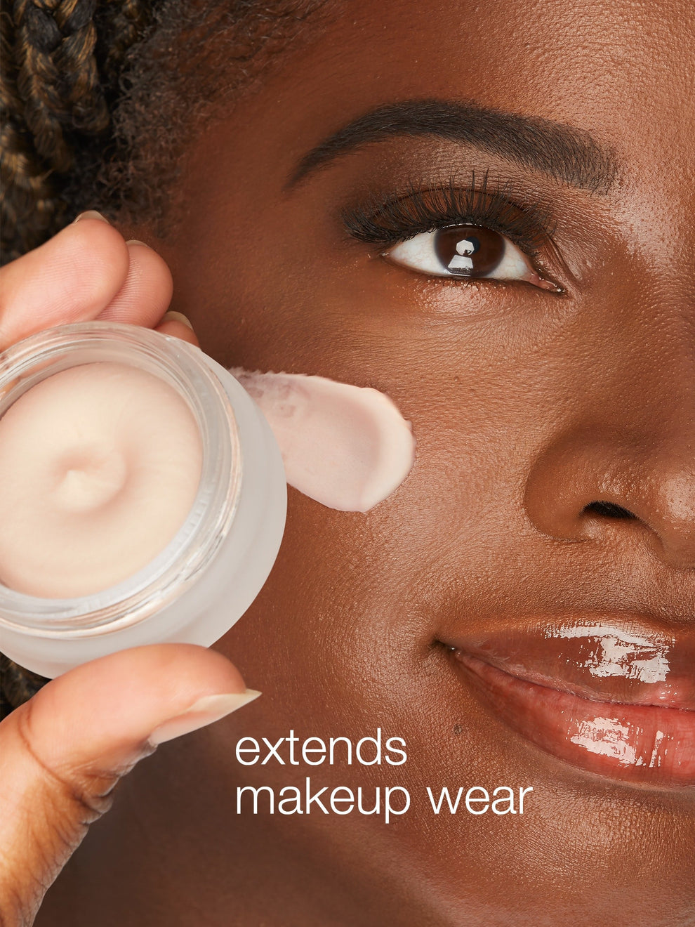 Person applying cream to face with text 'extends makeup wear'