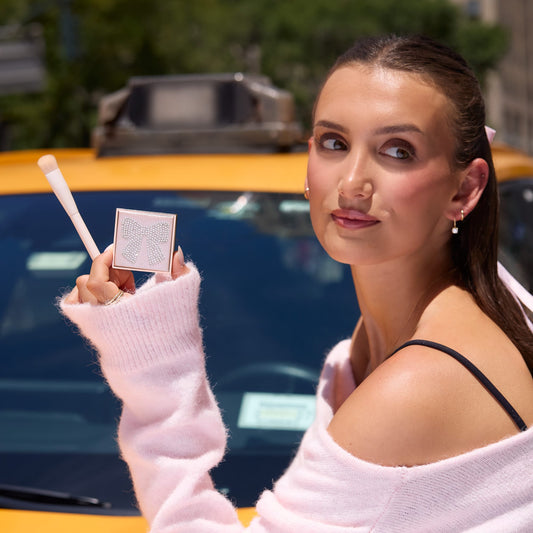 tarte cosmetics face card never declines, woman in nyc holding it in front of her while looking away