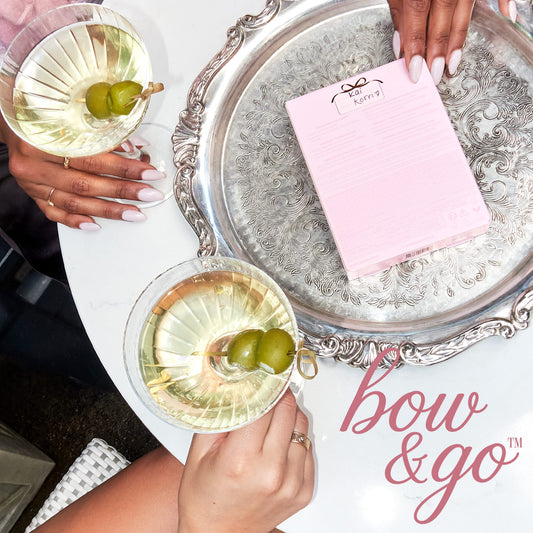 tarte cosmetics front row energy travel essentials on the table with two women drinking martinis