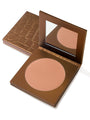 Bronze-colored makeup compact with open lid on a white background