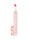 A pink lip treatment pen stands upright with an open cap displaying cherry patterns, labeled Tarte Cosmetics Maracuja Juicy Lip. It's placed against a plain white background.