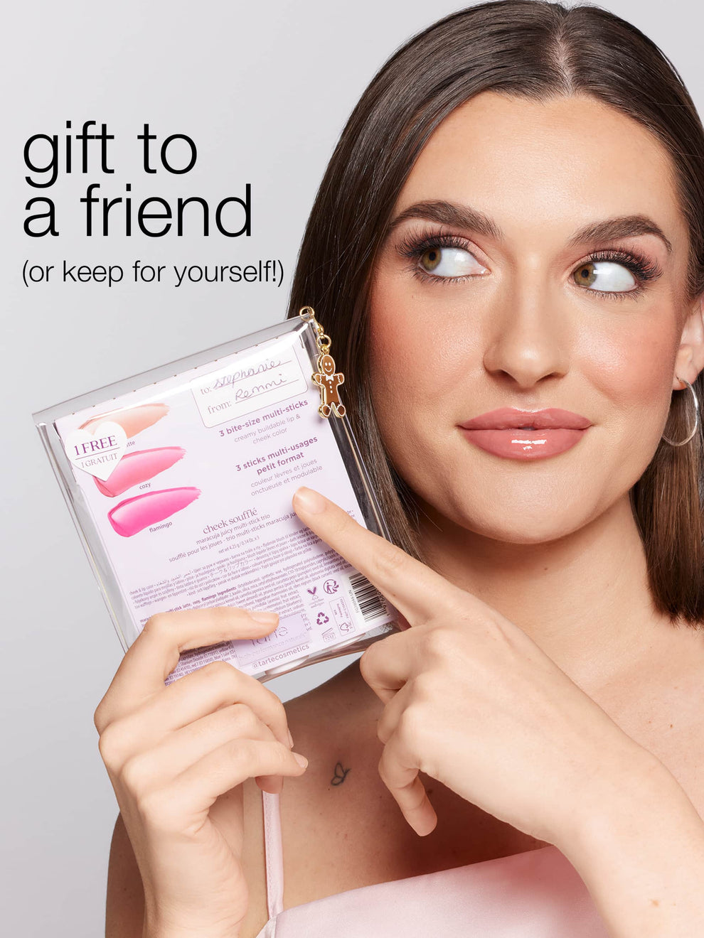 Woman holding a product package with text 'gift to a friend (or keep for yourself)' on a plain background