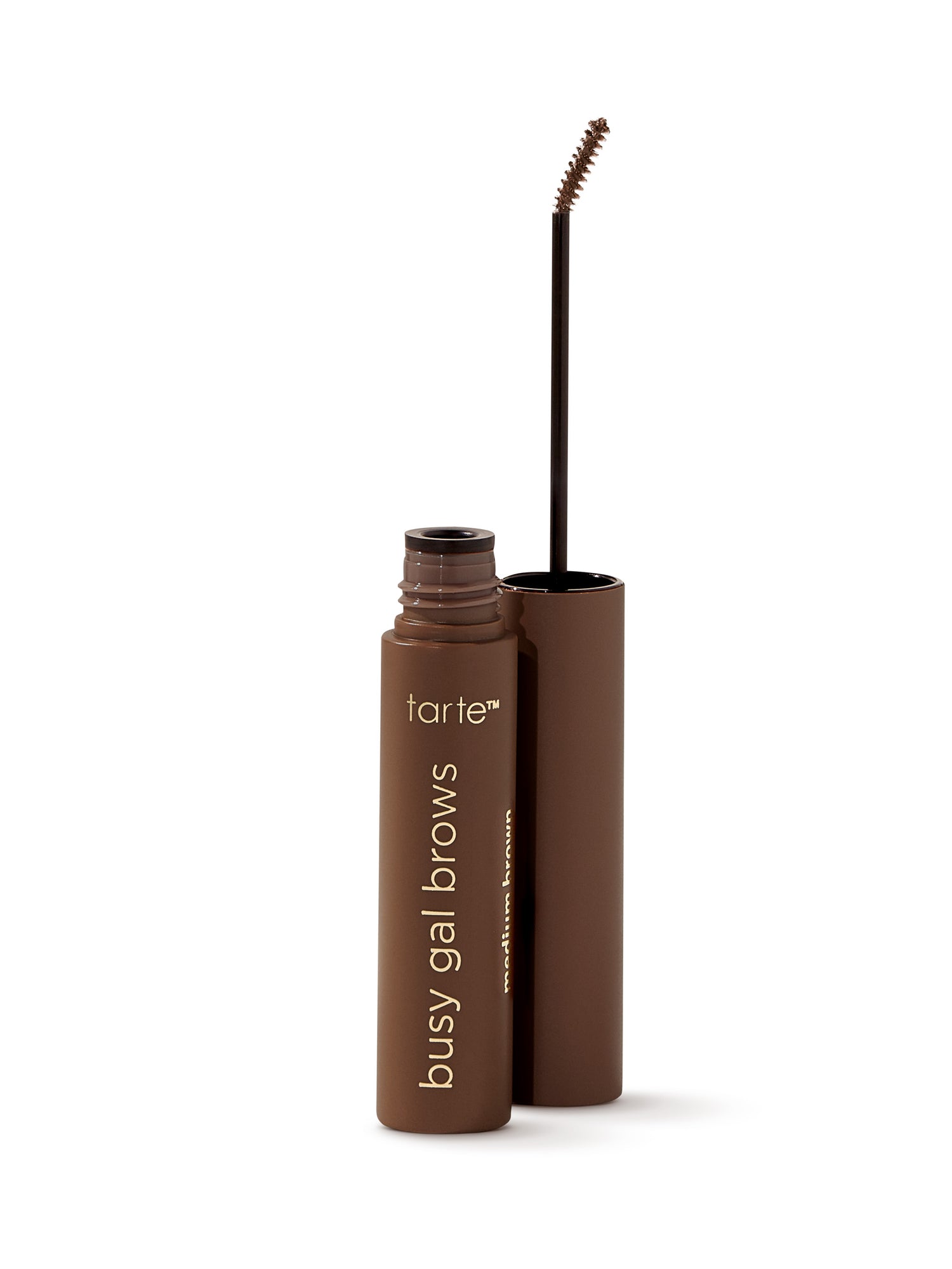 A cylindrical brown tube with Tarte Cosmetics and busy gal brows on it stands upright. The cap is removed, revealing a slender brow brush. The background is plain white.