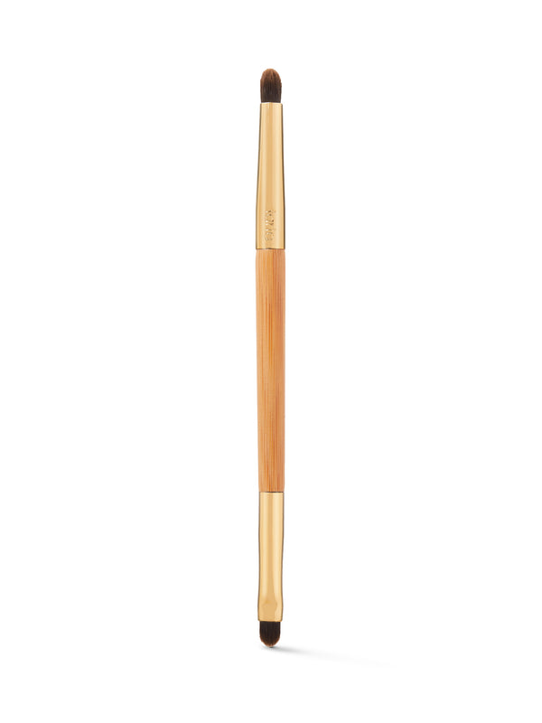 Makeup brush with wooden handle and black bristles on a white background