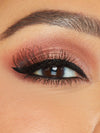 Close-up of an eye with smoky eye makeup and long lashes.