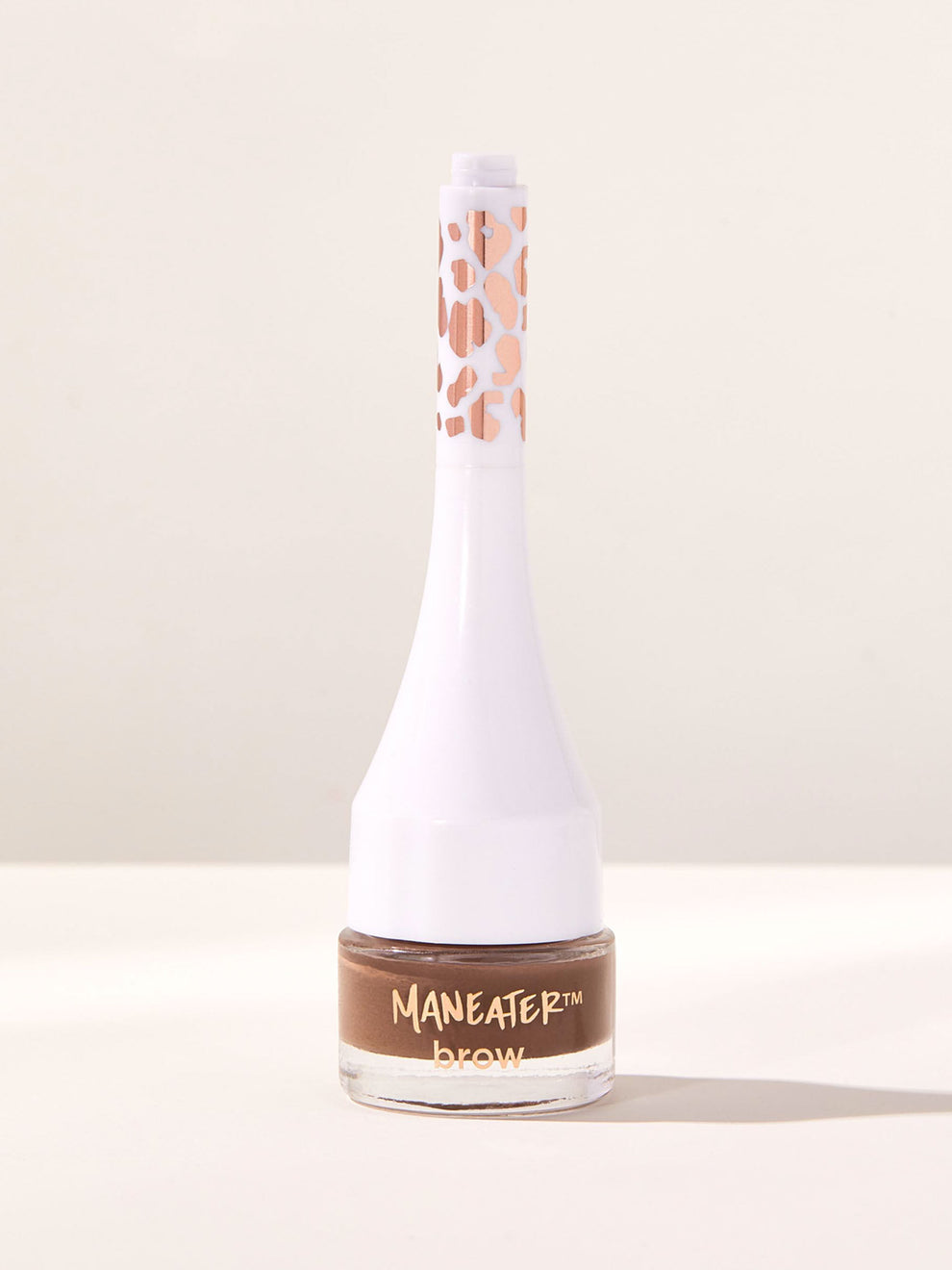 Bottle of Maneater brow product on a light beige background